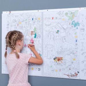 Mädchen malt in ein Malbuch, das an der Wand hängt